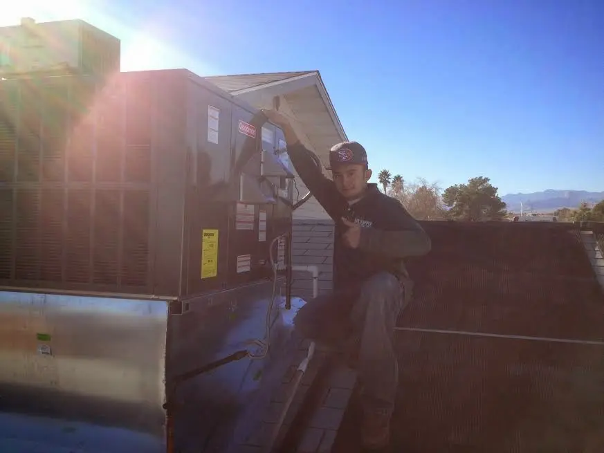 HVAC technician performing AC Tune-Up on a rooftop unit in Kingston